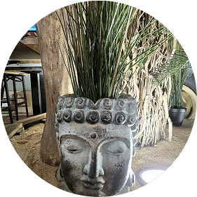 Tête de statue bouddhiste utilisée comme pot de fleur dans le restaurant Safari à Etrechy, élément décoratif au style zen et exotique.