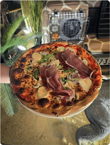 Pizza maison servie au restaurant Safari à Etrechy, photographiée dans un décor exotique et chaleureux.